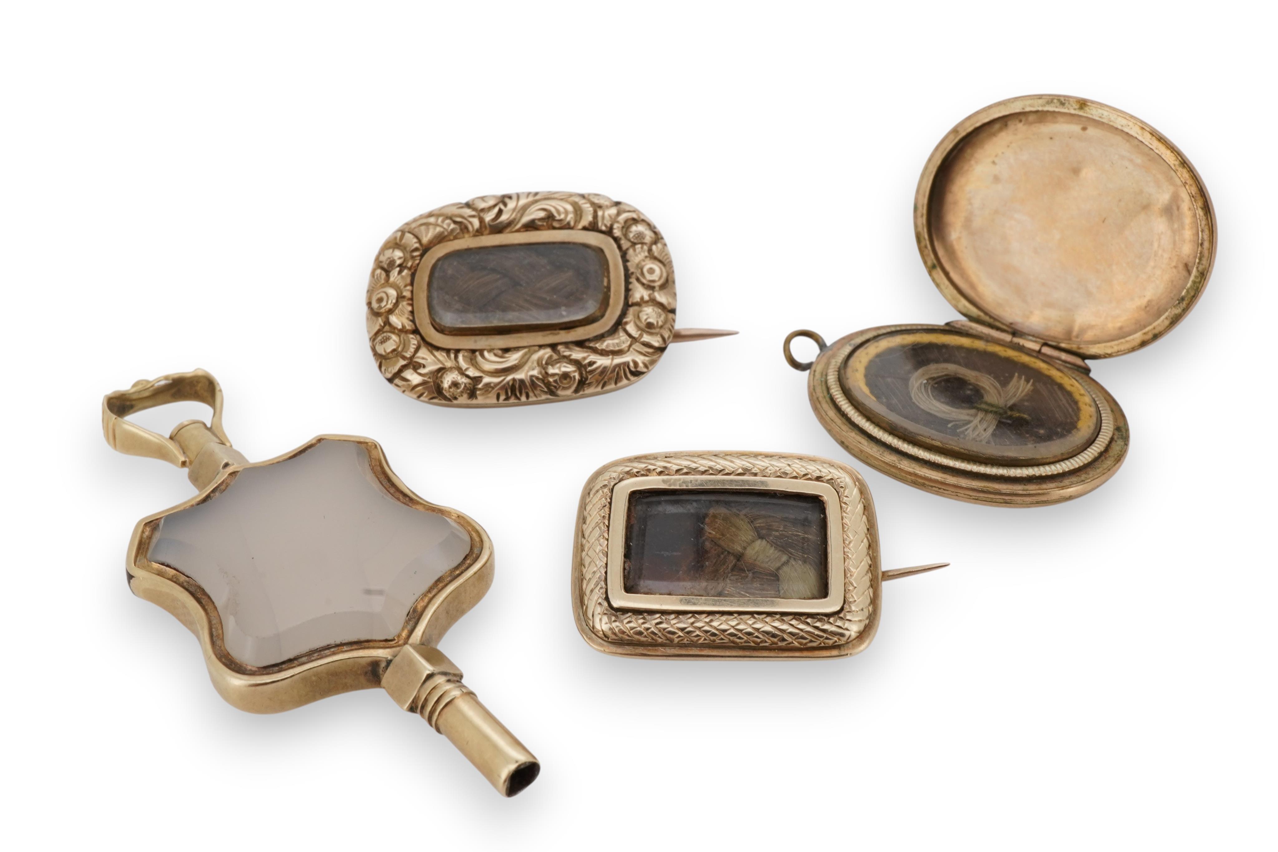 A locket, a watch key and two mourning brooches, the oval locket engraved with foliate details, opening to reveal a glazed panel of hairwork; together with two early 19th century mourning brooches, engraved with flowers